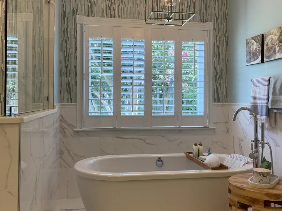 Primary bath with a freestanding tub and marble floor by Creative Construction Concepts