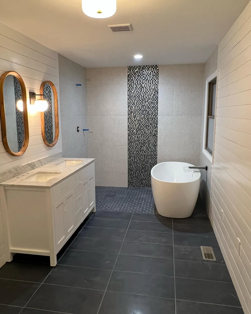 Primary bath, freestanding tub and pebble mosaic feature by Creative Construction Concepts