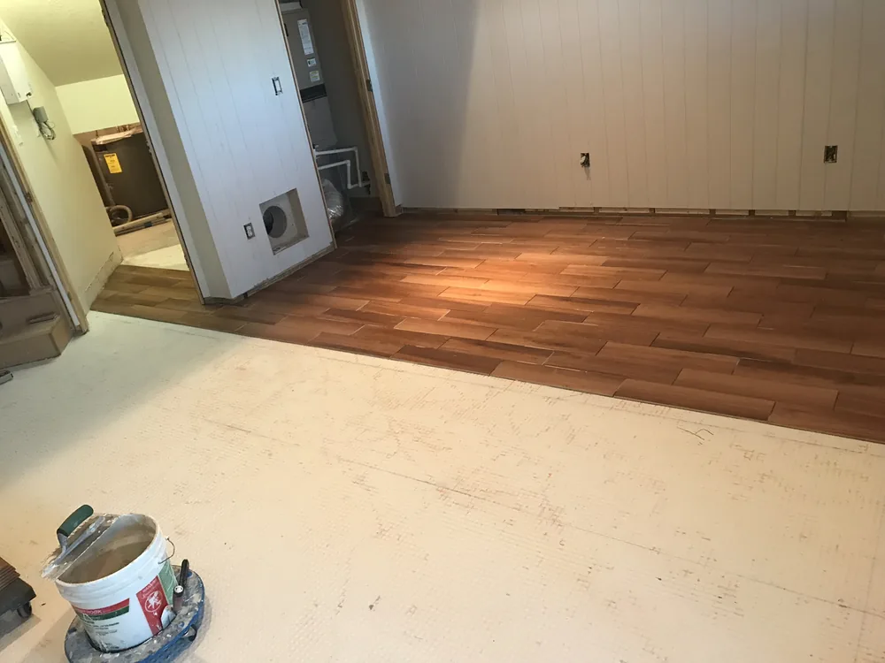Wood-look tile floor going in by Creative Construction Concepts