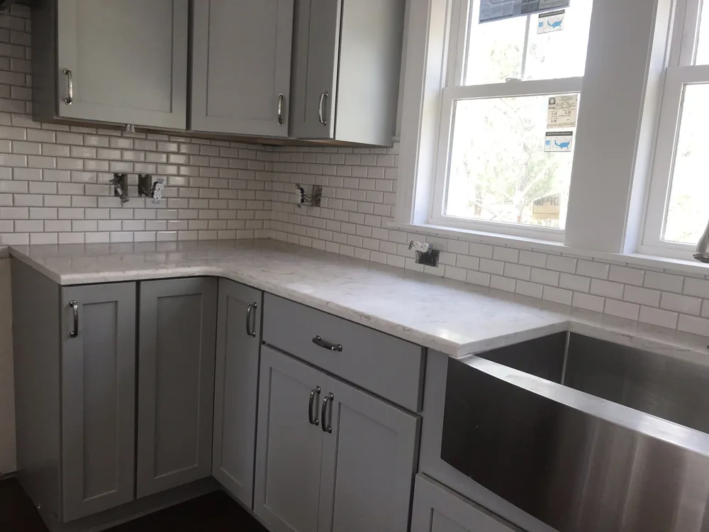 Kitchen remodel with beveled subway tile and farmhouse sink by Creative Construction Concepts
