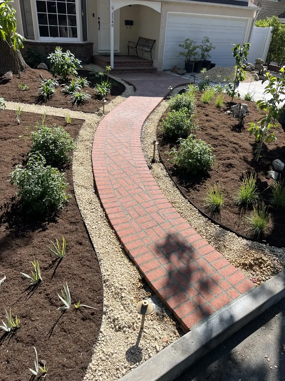 Curved brick garden walkway by Creative Construction Concepts