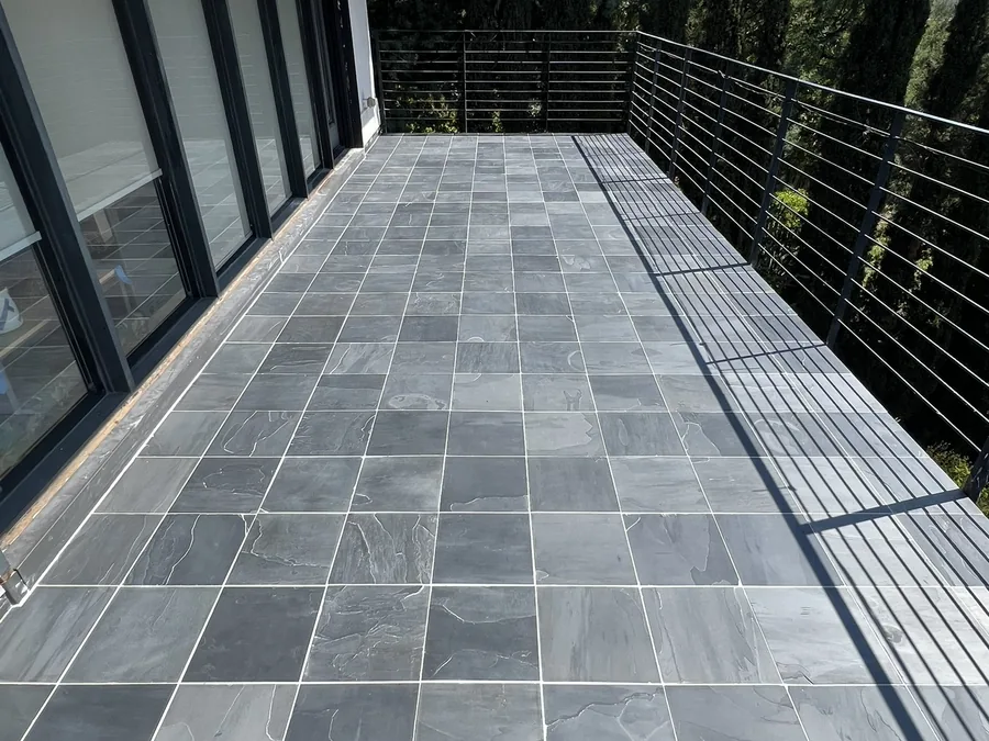 Slate tile deck with a cable rail by Creative Construction Concepts