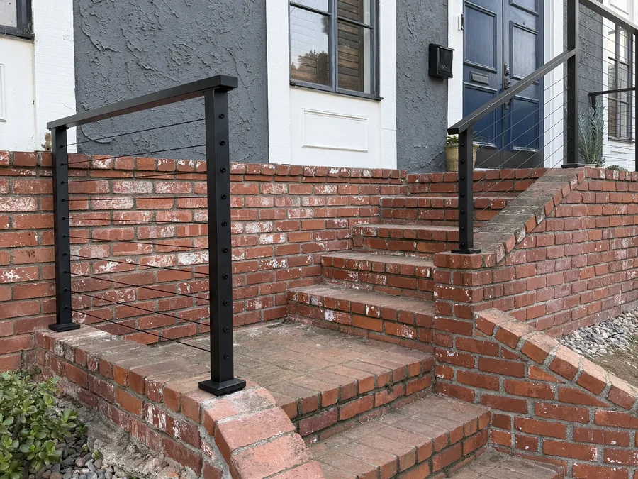 Brick entry steps with a curved retaining wall by Creative Construction Concepts
