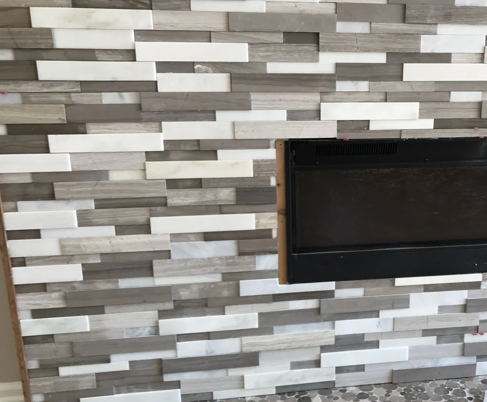 Stacked stone fireplace with pebble hearth by Creative Construction Concepts