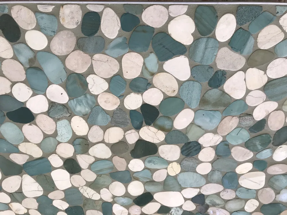 Flat-pebble stone accent wall by Creative Construction Concepts