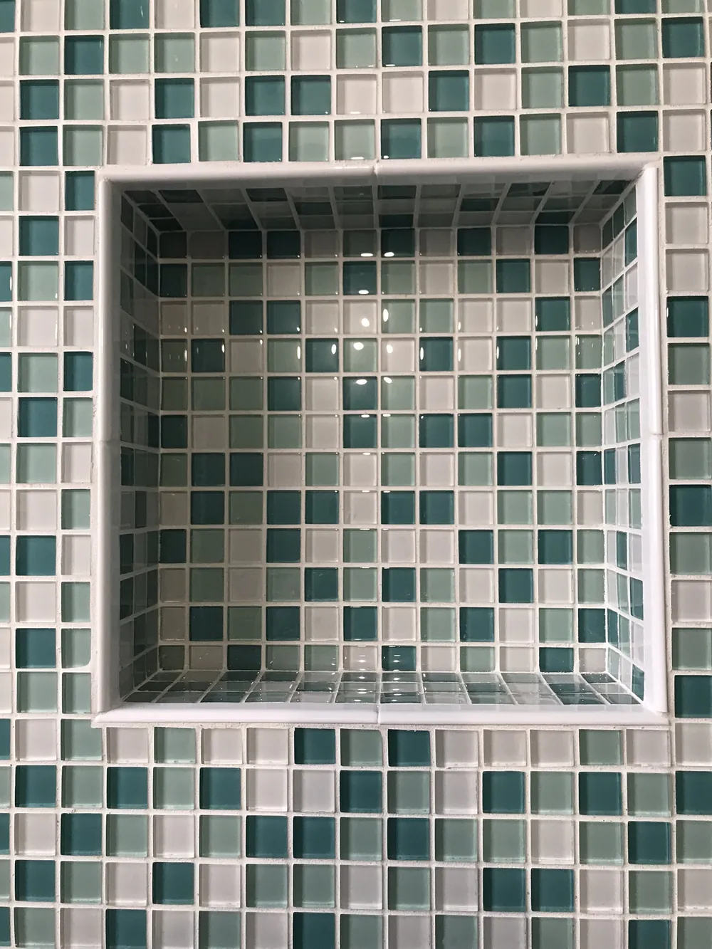 Green and white glass mosaic shower niche by Creative Construction Concepts