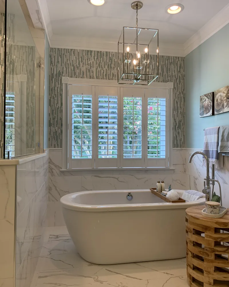 Primary bath with a freestanding tub and marble floor, by Creative Construction Concepts in Los Angeles