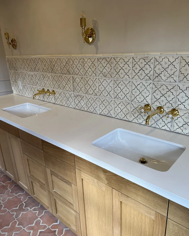 Custom vanity, patterned backsplash, wall-mount brass, by Creative Construction Concepts in Los Angeles
