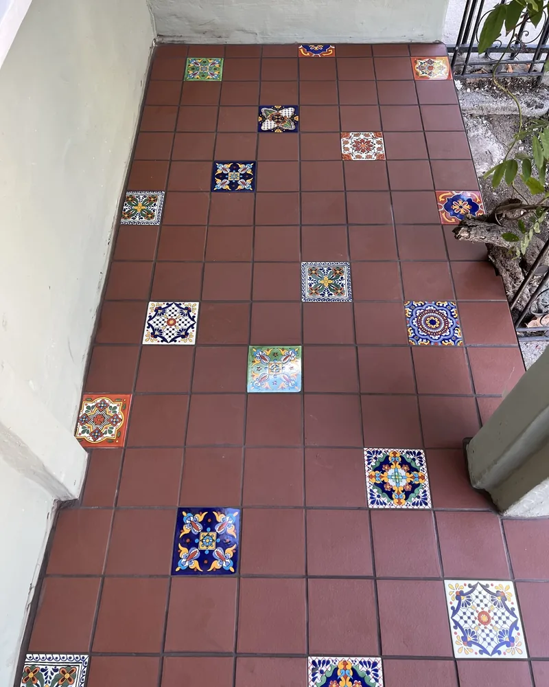 Terracotta patio with hand-painted Talavera accents, by Creative Construction Concepts in Los Angeles