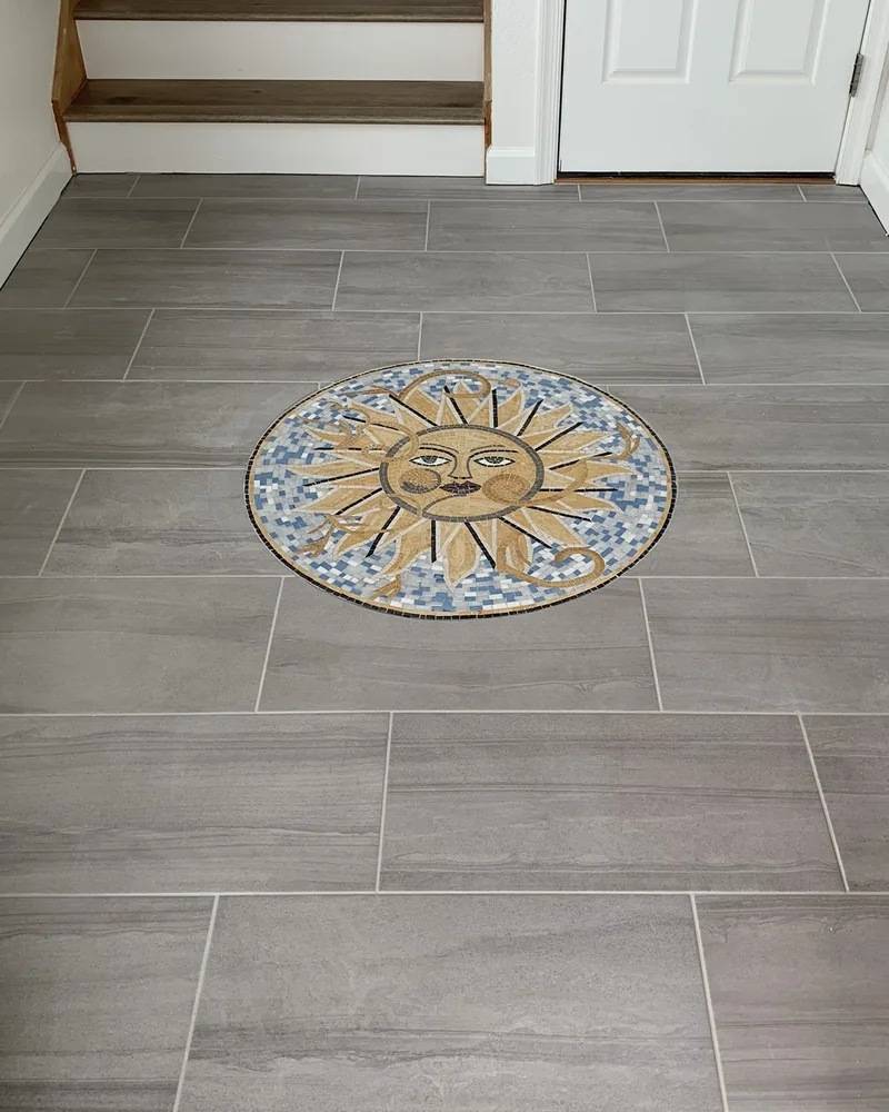 Custom sun medallion set into a wood-look tile floor, by Creative Construction Concepts in Los Angeles