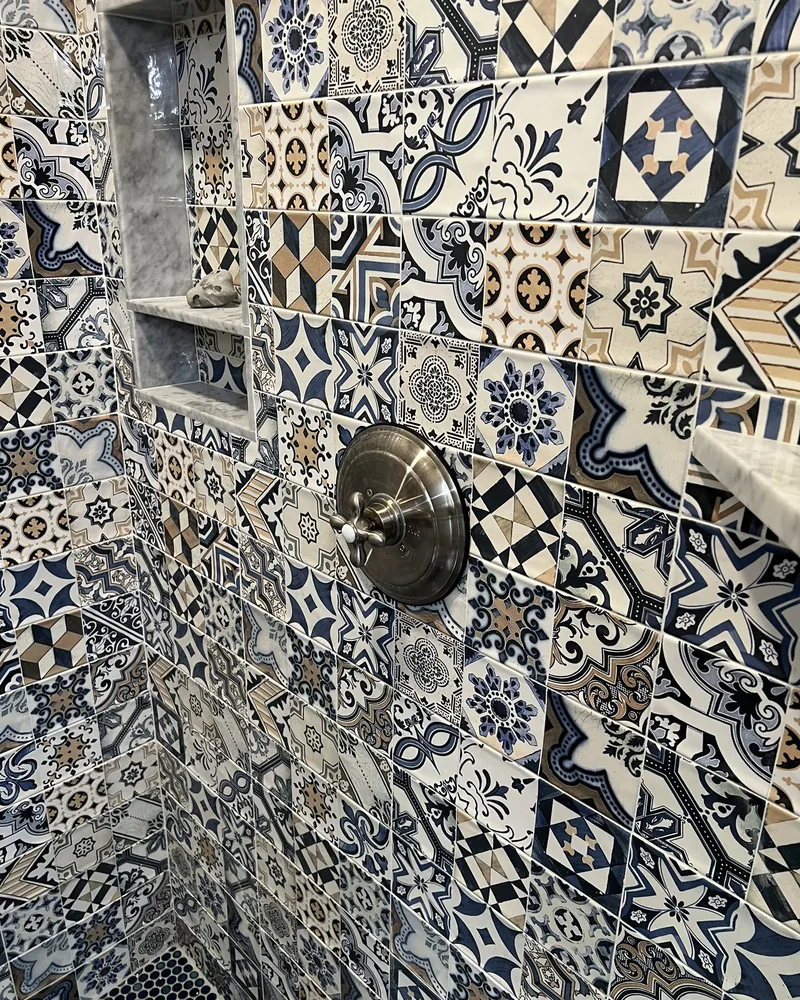 Patterned Talavera shower wall with a built-in niche, by Creative Construction Concepts in Los Angeles